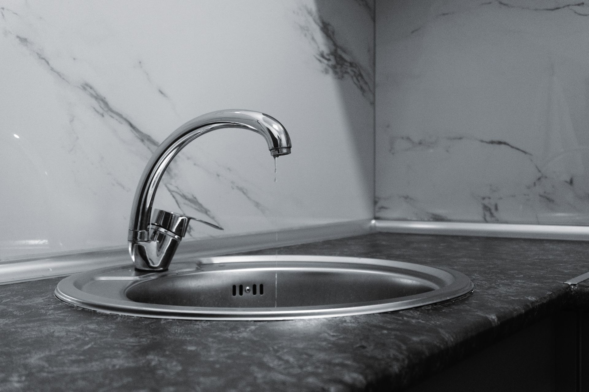 A clean and modern kitchen sink with a chrome faucet, highlighting minimalist design and water conservation.
